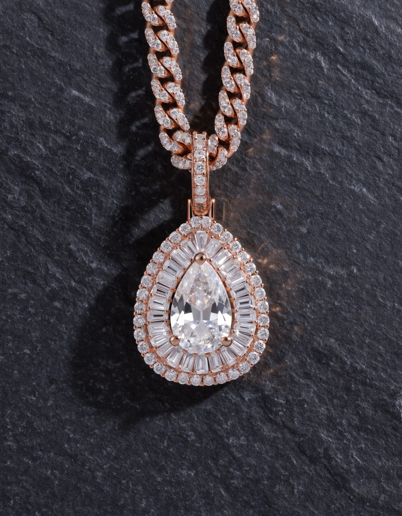 Pear-shaped clear stone pendant with a baguette halo and stone-set chain