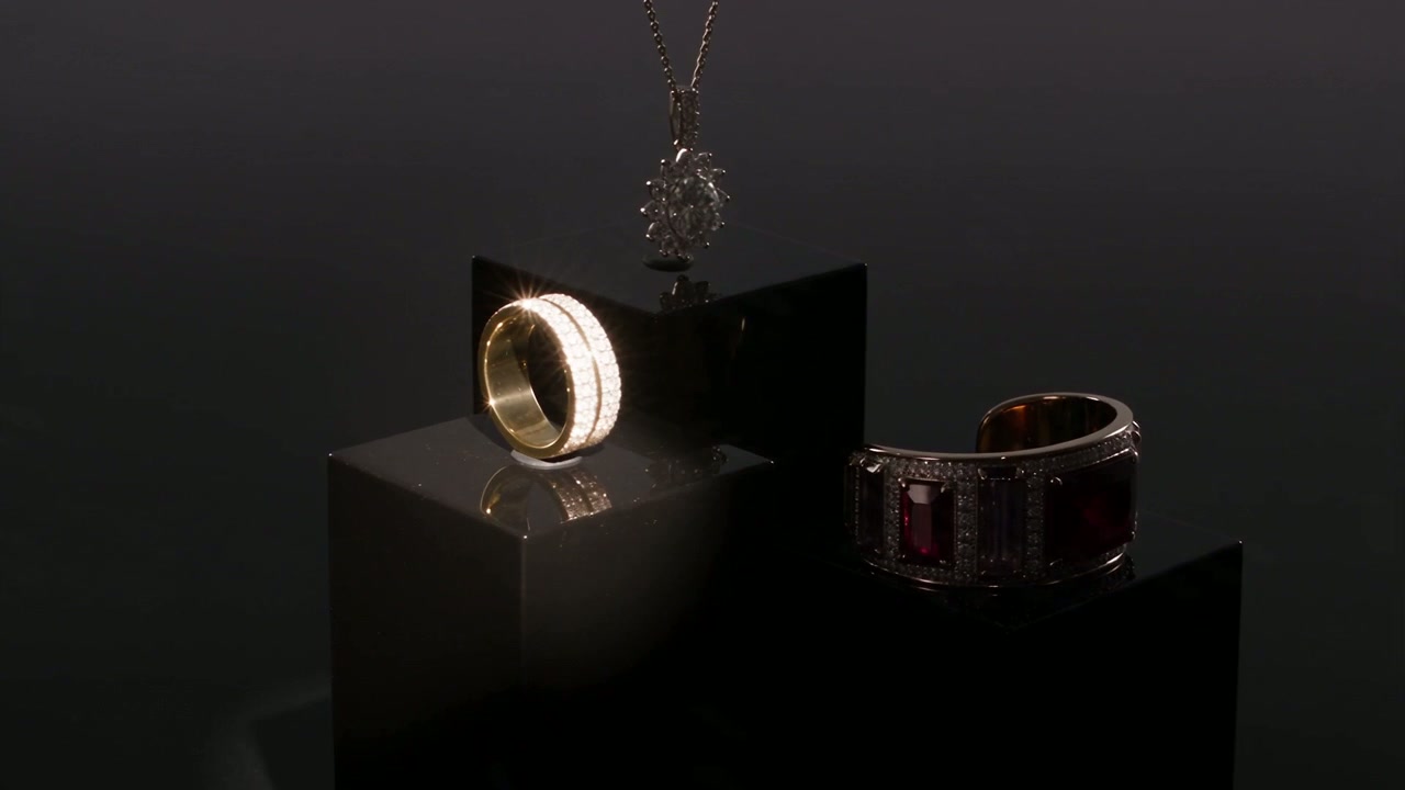 A curated arrangement of PLUGS+ jewelry on black plinths